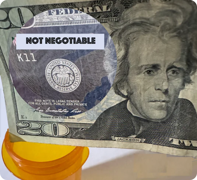 image of a $20 bill behind held against the lid of a pill bottle.